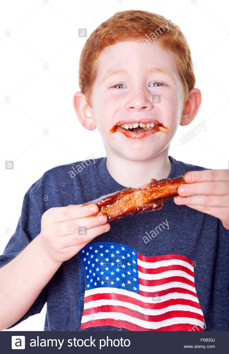 hungry-boy-eating-bbq-rib-in-studio-F0B33J.jpg